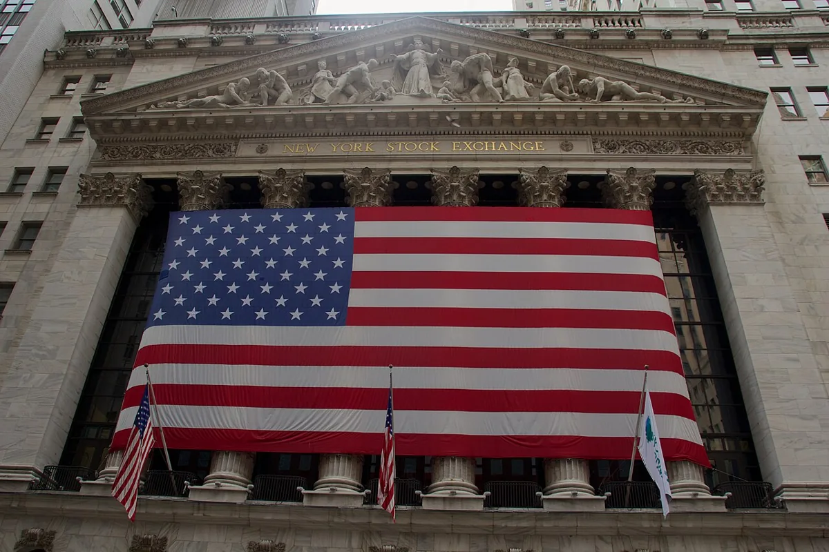 An American flag hangs across the columned facade of the New York Stock Exchange.